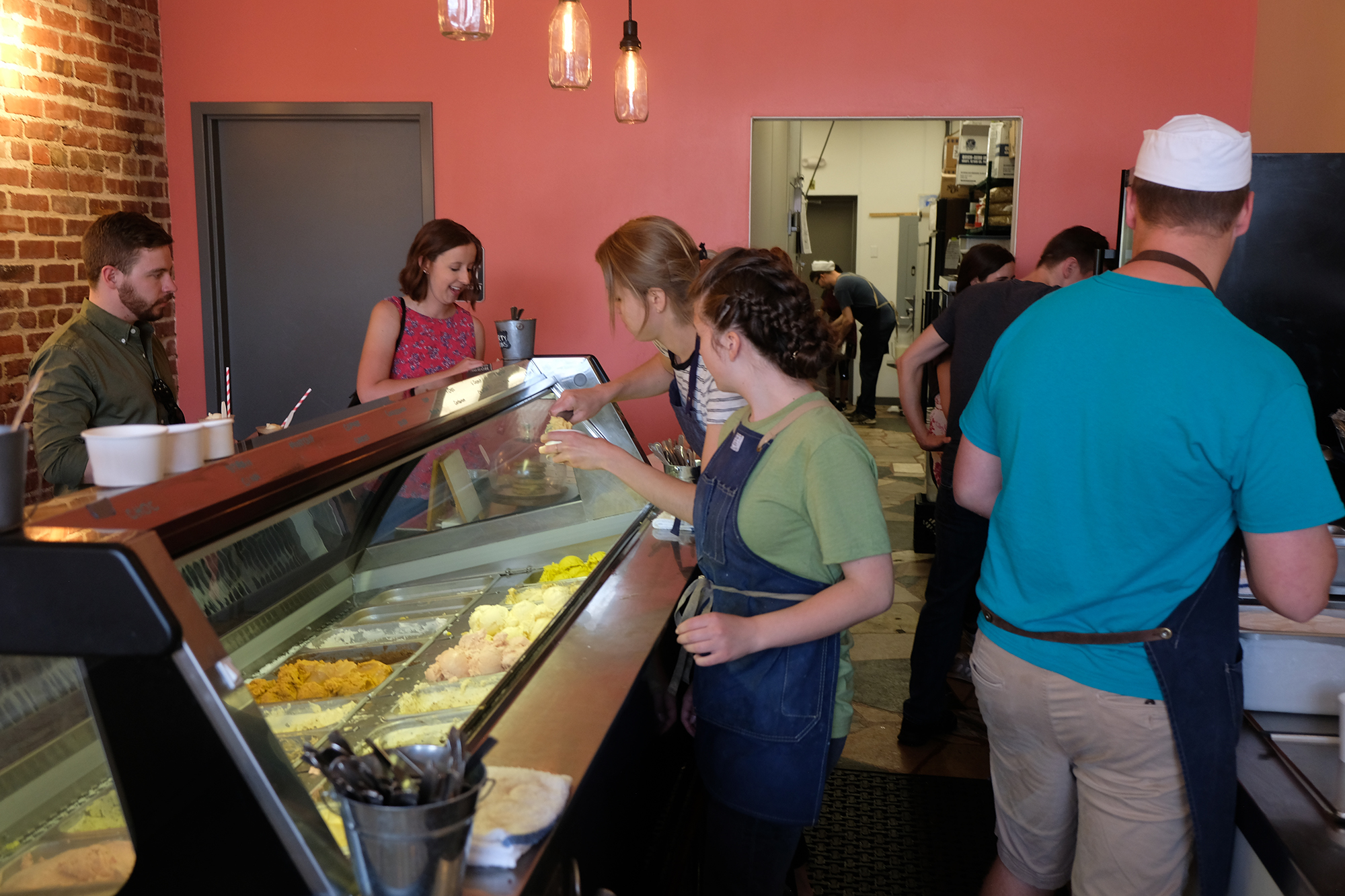 Workers serving ice cream scoops at Coneflower Creamery.