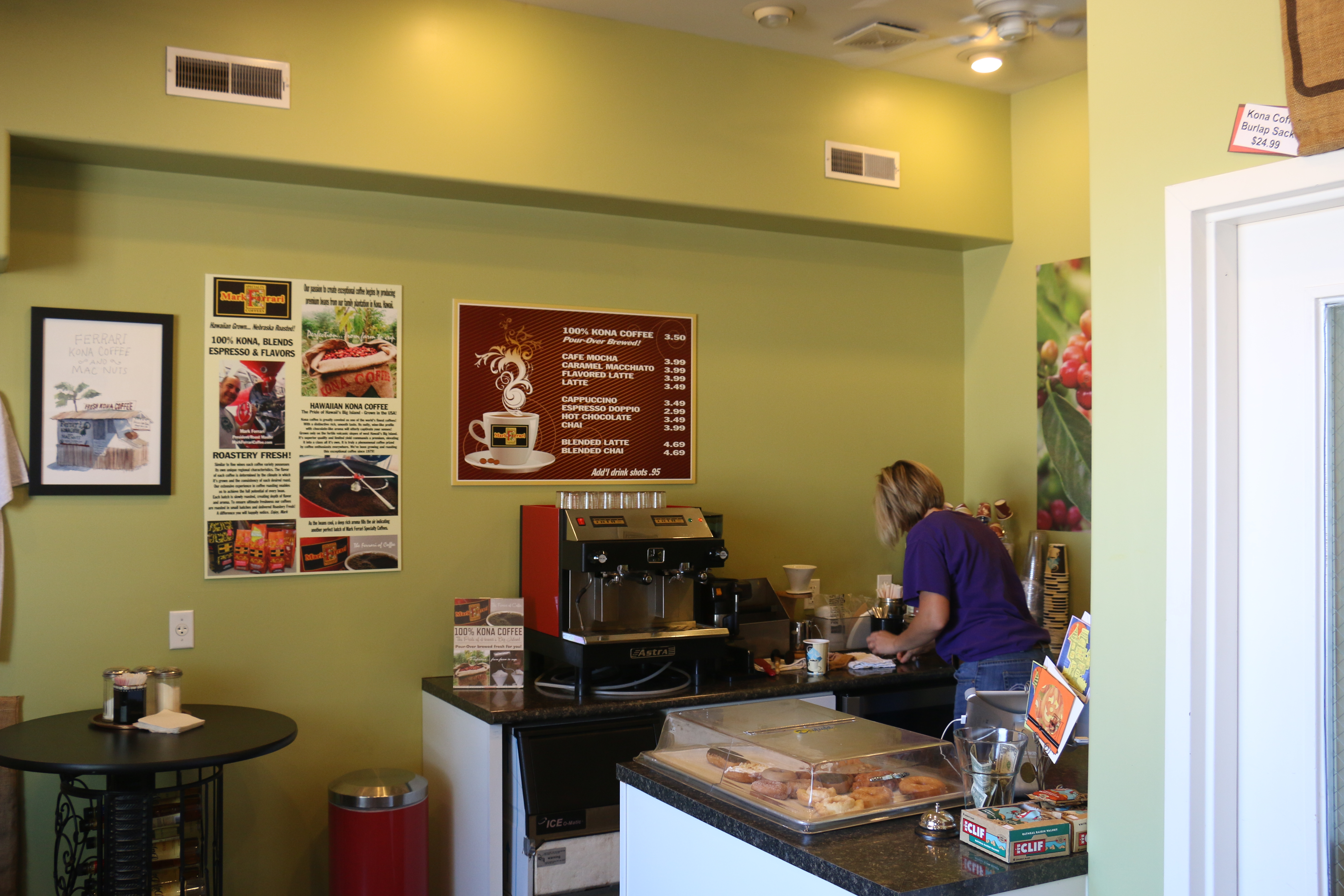 Someone fixing coffee behind a counter of pastries at Mark Ferrarri's Coffee in Oshkosh.