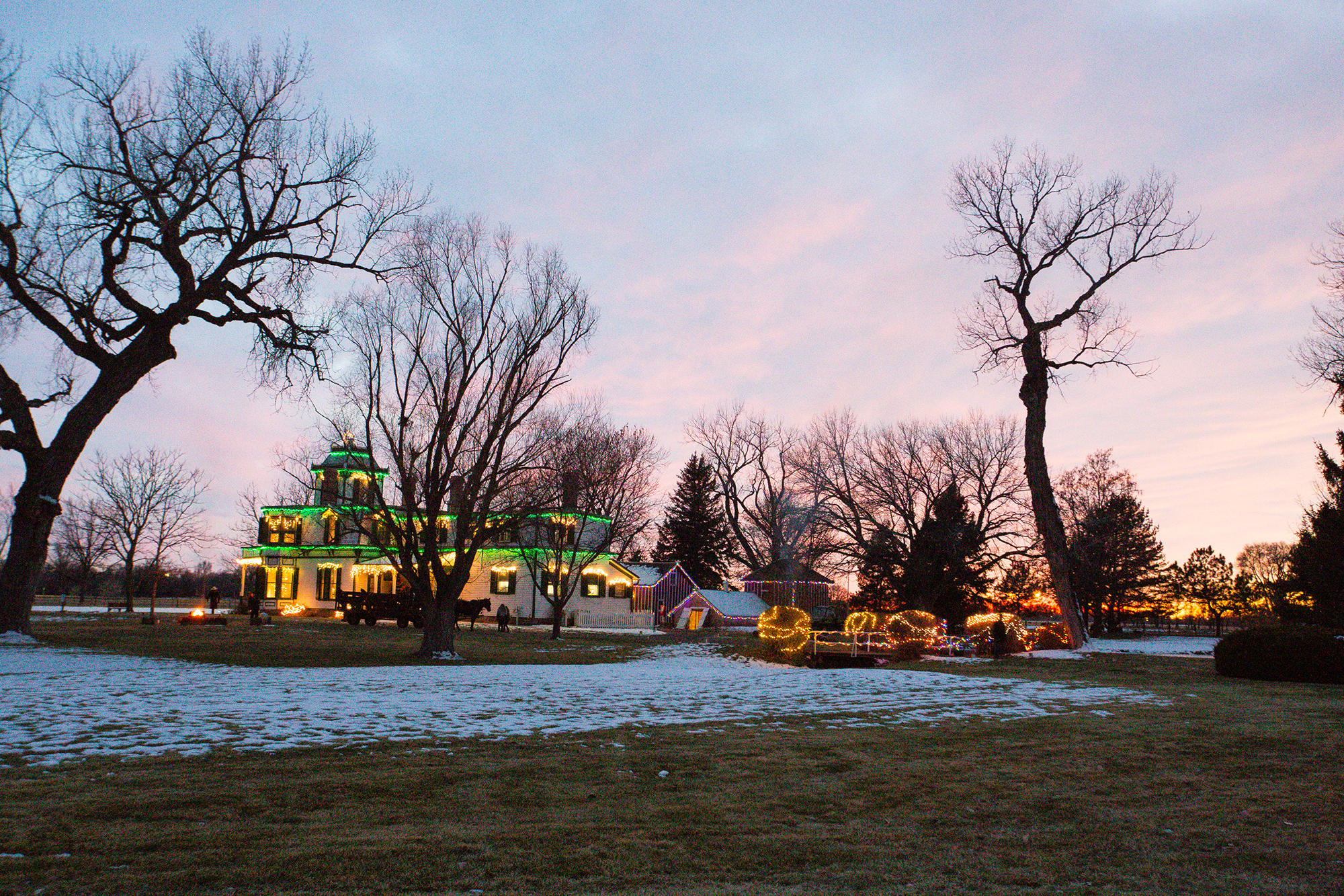 Buffalo Bill's mansion decorated in Christmas lights at dusk.