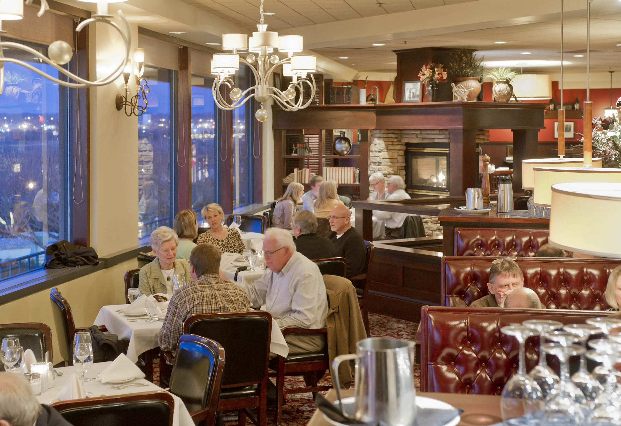 Folks dining inside Kahill's Chophouse next to windows overlooking the Missouri River.