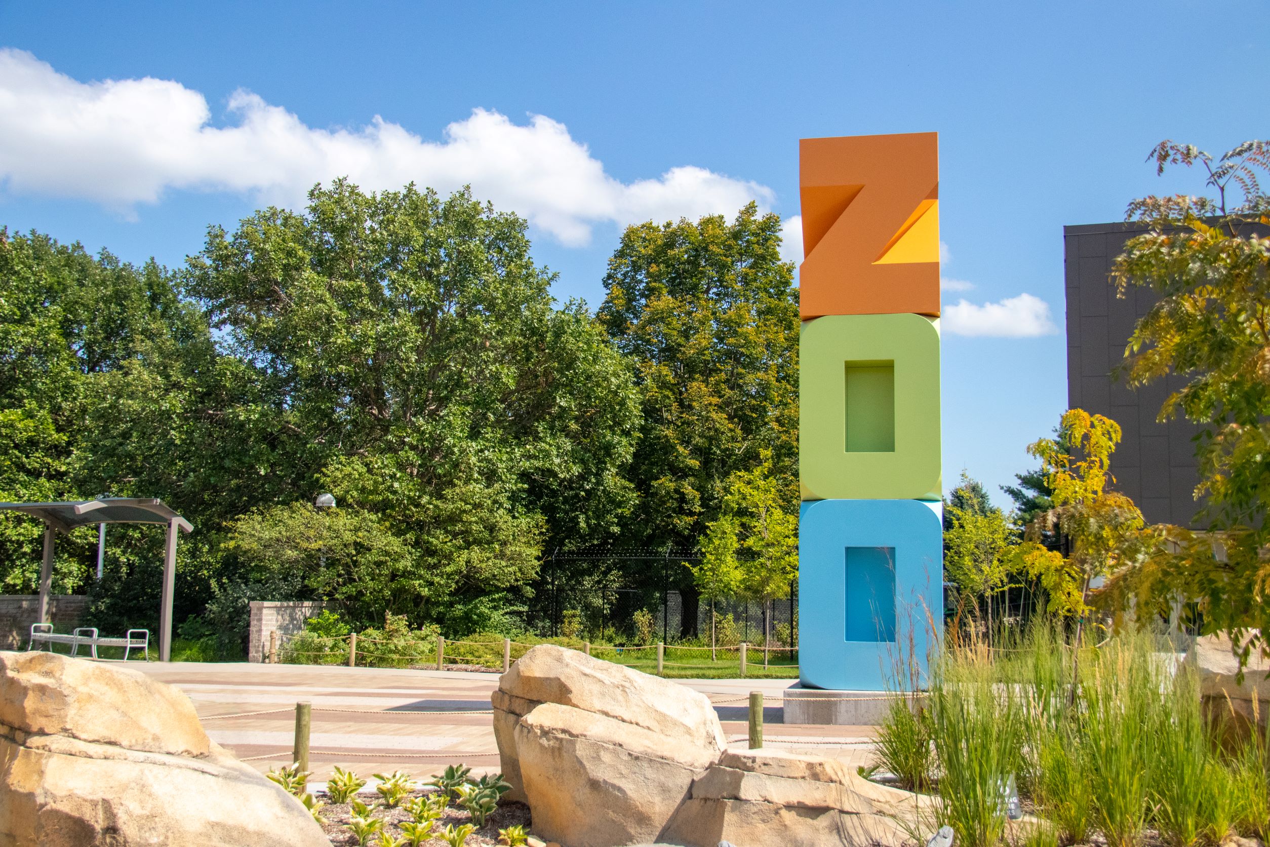 Zoo sign among rocks and a garden at Lincoln Children's Zoo.