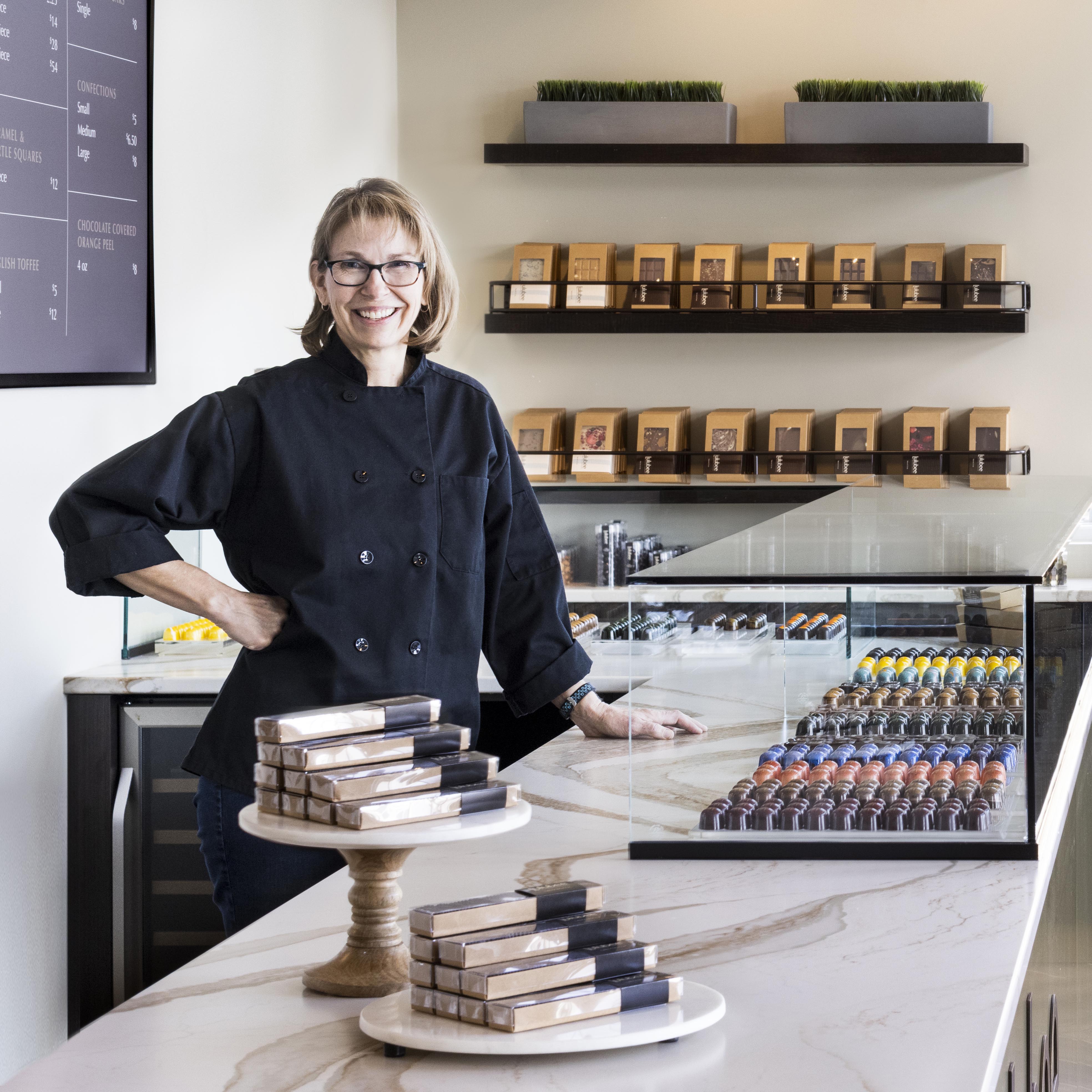 Shop owner behind the chocolate counter at Lulubee Artisanal Chocolates.
