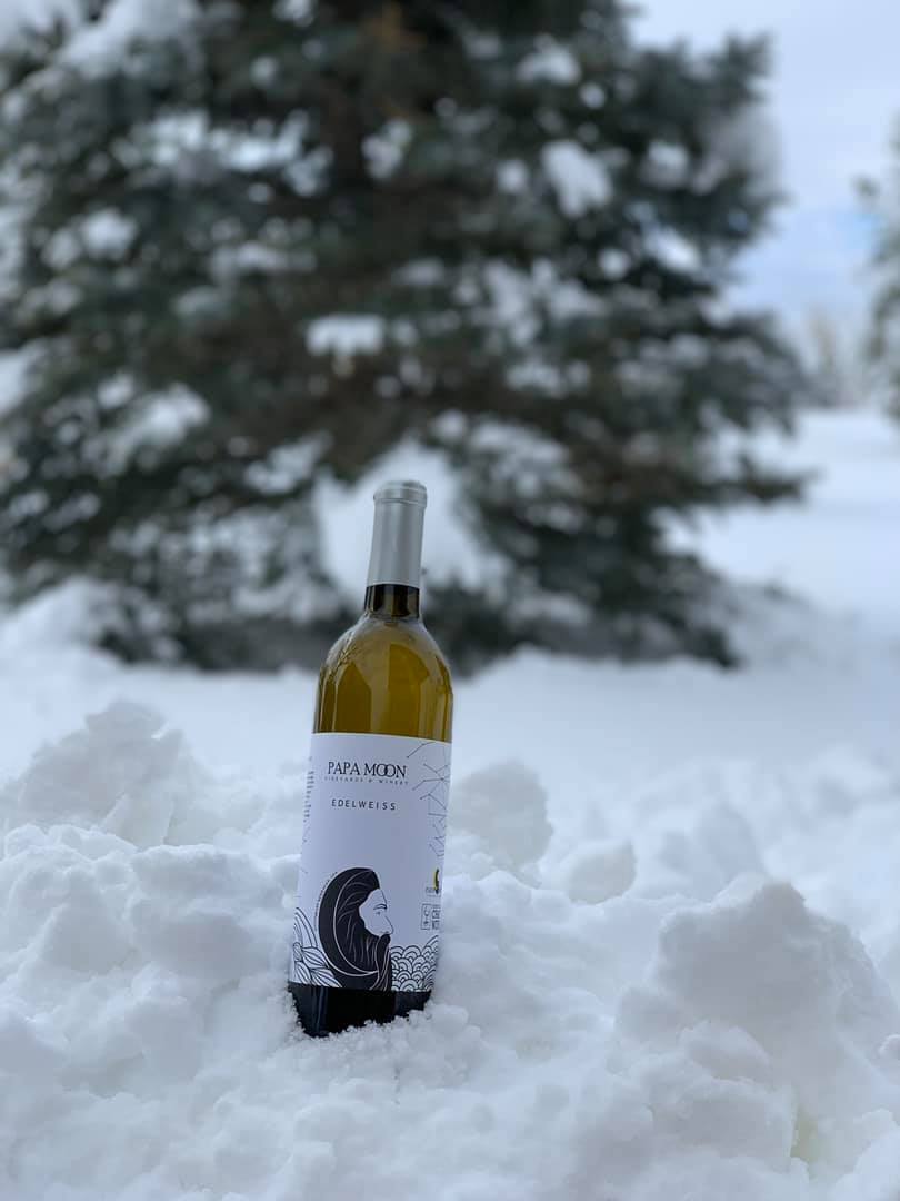 A bottle of wine from Papa Moon Vineyards tucked into the snow.