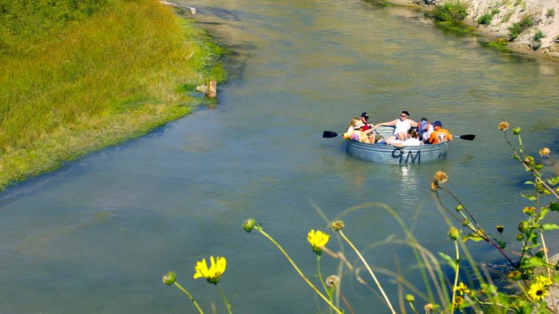 People floating down a Nebraska river in a livestock tank. 