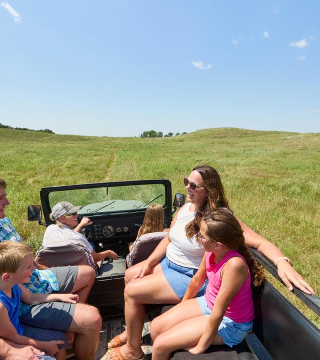 Calamus Outfitters leading a family on a Sandhills tour in a open-back truck.