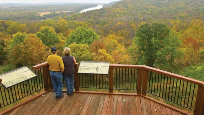 Couple taking in the fall foliage on an overlook at Indian Cave State Park in Shubert, Nebraska.